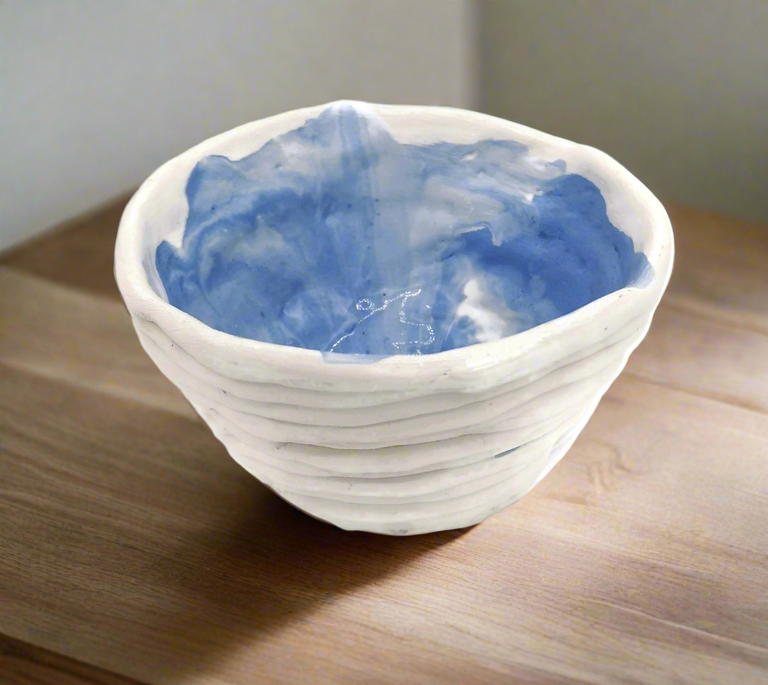 White ceramic bowl with blue interior on a wooden surface