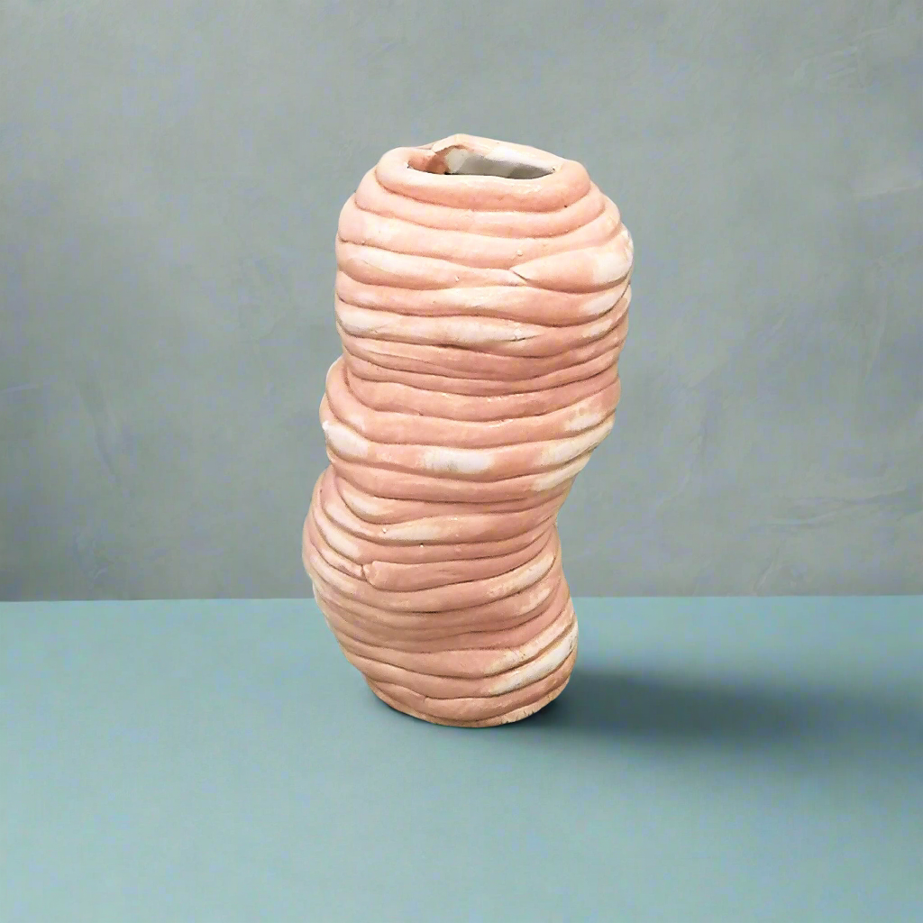 Textured pink ceramic vase on a gray background