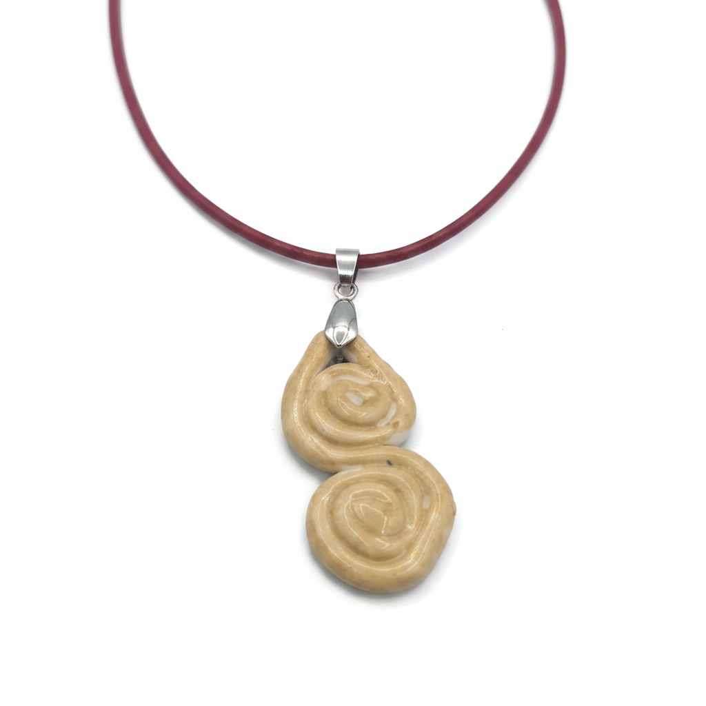 Handmade ceramic infinity pendant on a neutral background