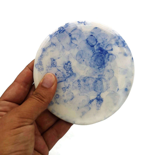 Handmade blue ceramic coaster held in one hand