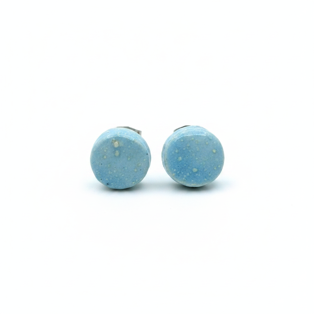 Pair of blue speckled handmade ceramic stud earrings on white background