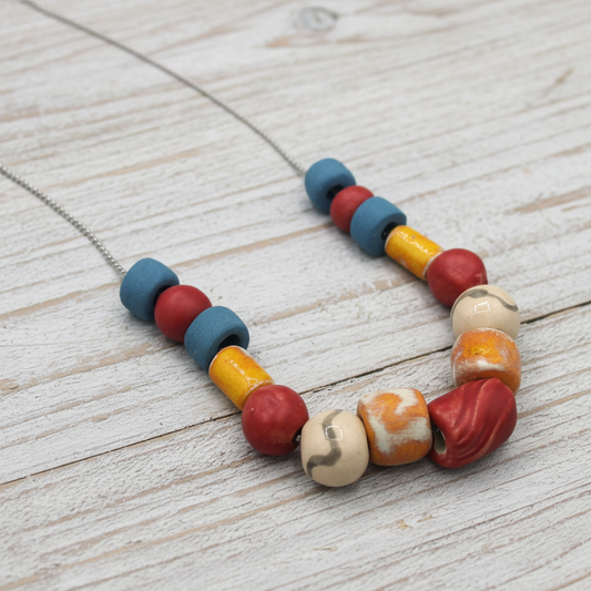 Long handmade ceramic bead necklace in blue orange and red